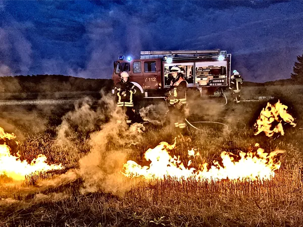 Bild zeigt ein brennendes Feld, dass gelöscht wird.